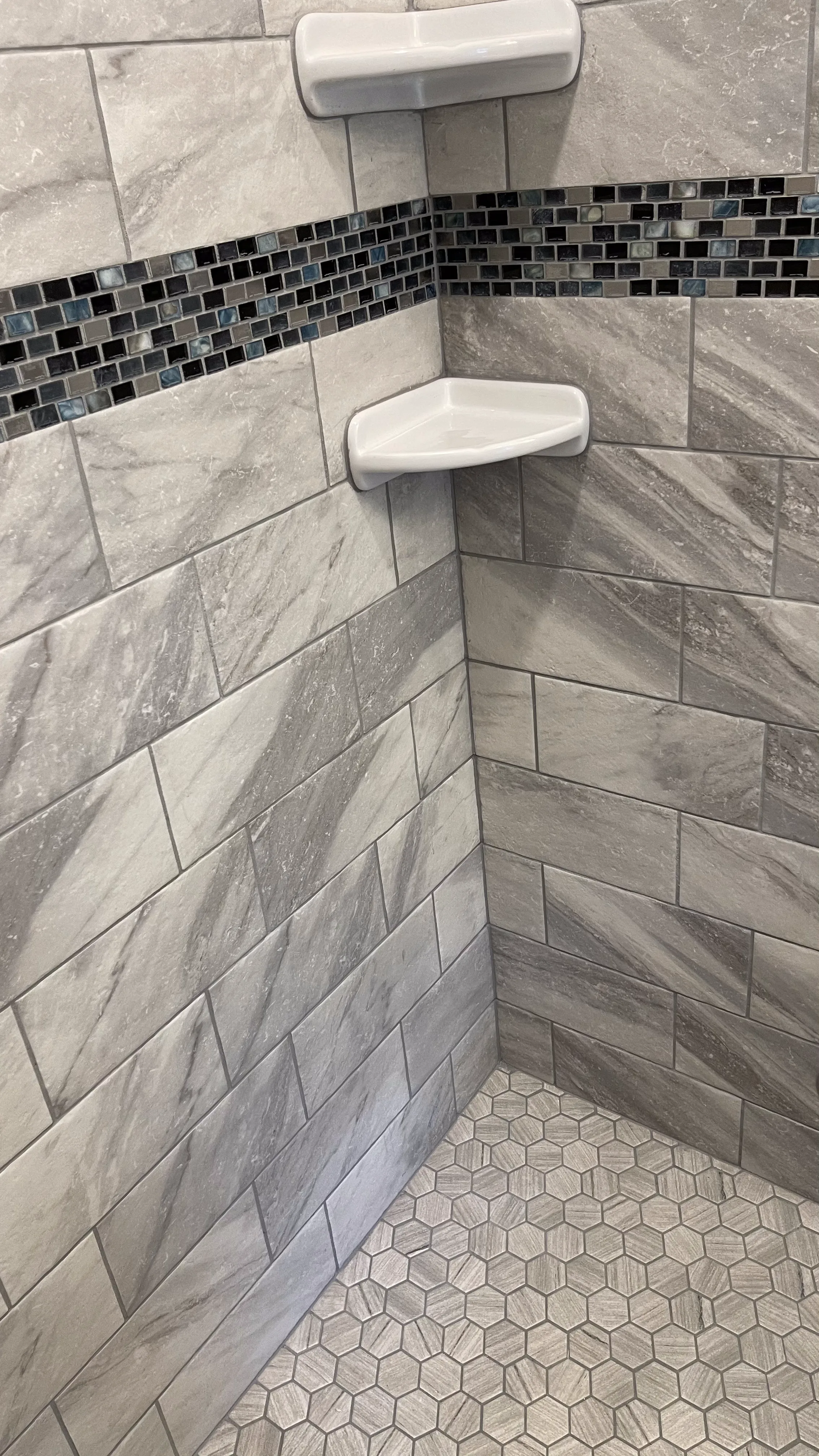 Tiled shower niche with mosaic accent band