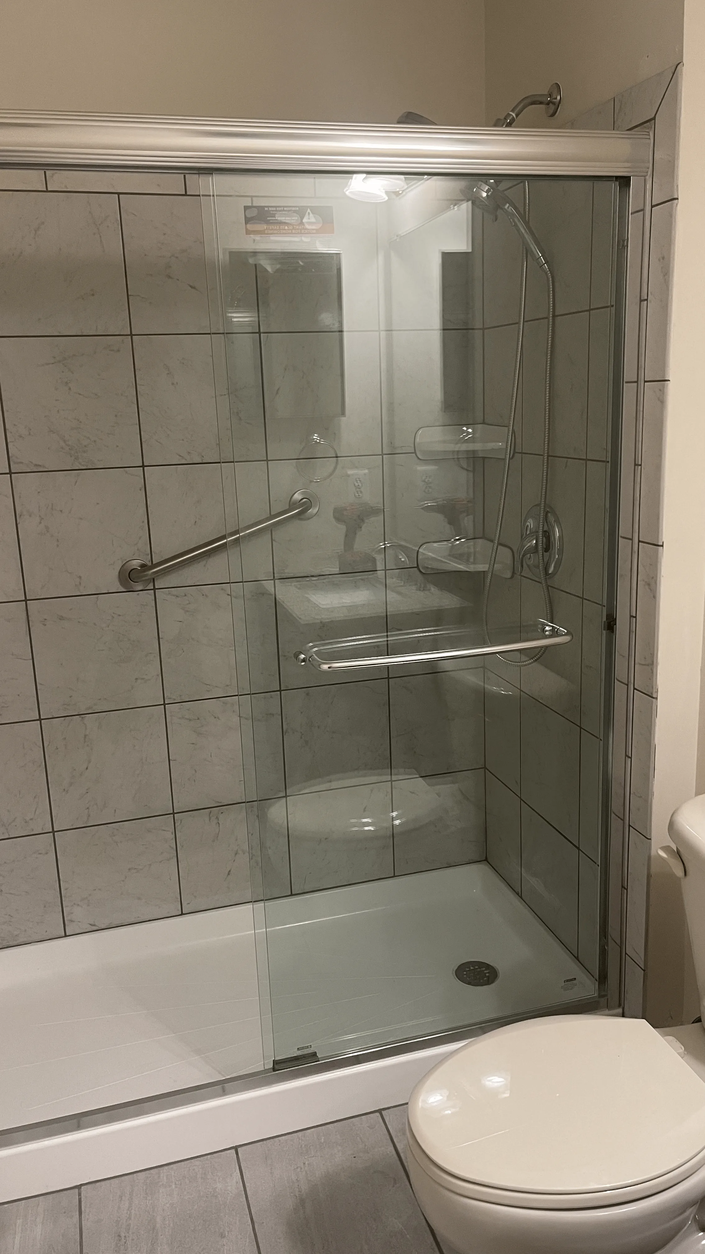 Glass-enclosed shower in a completed bathroom remodel